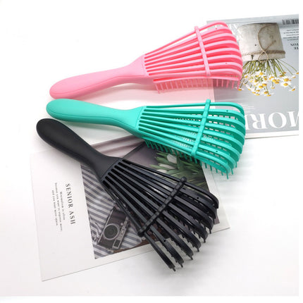 Hair detangling brush side view showing ergonomic handle design