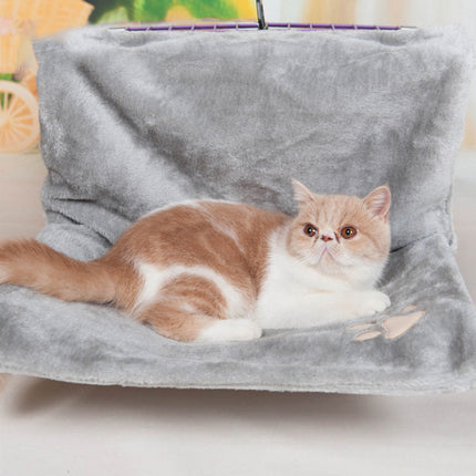 Cat lounging in hanging bed mounted to wall in modern home setting